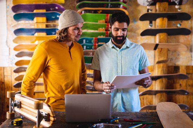 Diverse male workers in skateboard shop with multiple and colourful skateboards. Global sport and skateboard shop concept.