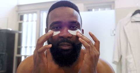 man applying under-eye patches for refreshing skincare routine - Download Free Stock Images Pikwizard.com
