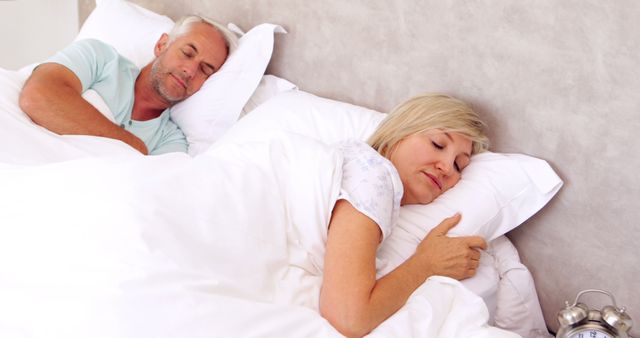 Peaceful couple sleeping in bed at home in bedroom
