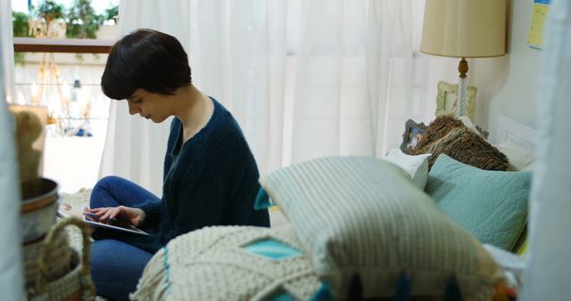 Young Woman Reading Book Near Window in Cozy Natural Light Bedroom - Download Free Stock Images Pikwizard.com