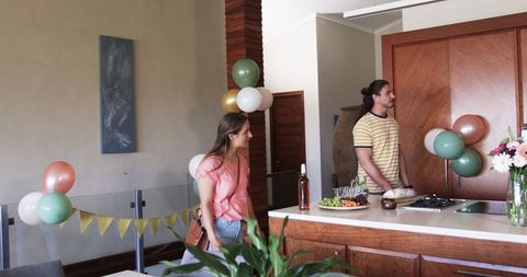 Friends preparing home for celebration with balloons and decorations