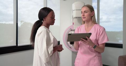 Nurse Consulting with African American Patient Before Mammogram in Radiology Clinic