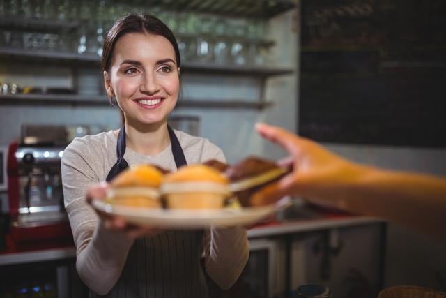 Smiling Waitress Serving Cupcake Plate in Cozy Café - Download Free Stock Photos Pikwizard.com