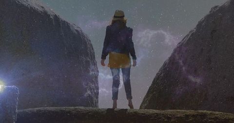 Adventurous explorer stands under starry cosmos