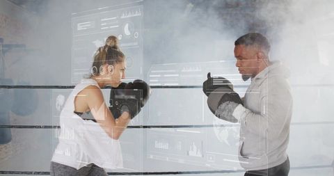 Female boxer training with coach holding focus mitts in smoky boxing ring
