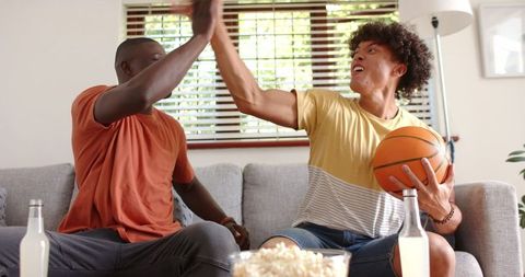 Excited Friends Celebrating Basketball Success with High Five