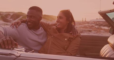 Happy Couple Enjoying Sunset Drive in Convertible Car