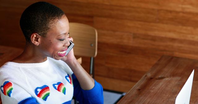 Young Woman Smiling While Talking on Phone at Wooden Desk - Download Free Stock Images Pikwizard.com