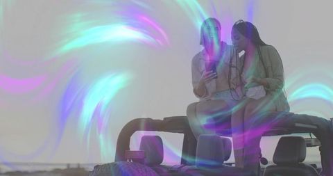 Carefree Friends Enjoy Coastal Adventure with Smartphone