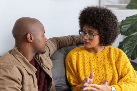 African american couple having deep conversation on couch showing emotional communication