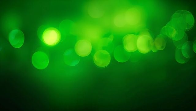 Glowing green bokeh background with soft halos and layered light orbs