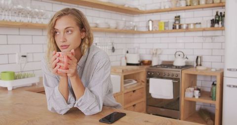 Woman Enjoying Tea in Cozy Modern Kitchen Scene
