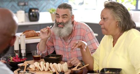 Senior Friends Enjoying Asian Lunch at Home Gathering
