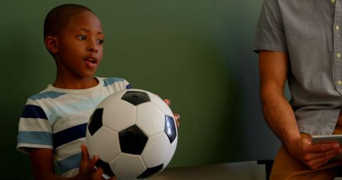 Schoolboy Presenting About Soccer Ball in Classroom