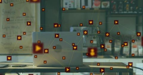 Laptop and smartphone connecting social network with floating icons over coffeehouse workspace