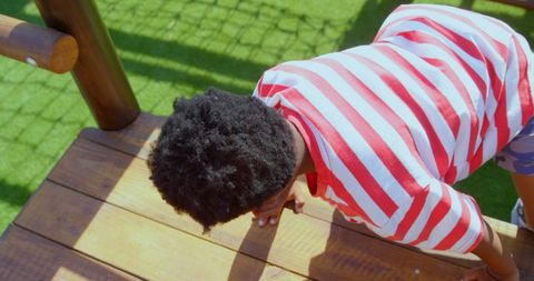 Schoolboy Climbing Playground Structure on Sunny Day