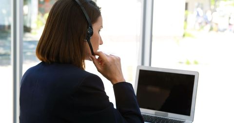 Businesswoman Using Laptop for Virtual Meeting with Headset - Download Free Stock Images Pikwizard.com