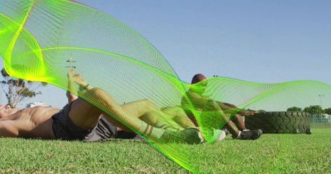 Shirtless men training core outdoors with tire, team strength and neon wave graphic