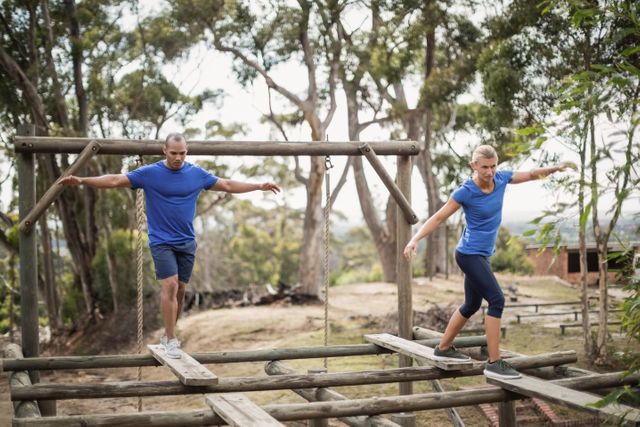 Fit man and woman during obstacle course training at boot camp