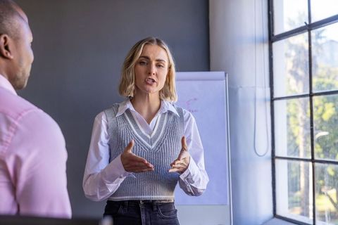 Diverse Coworkers Discussing Presentation Near Office Window