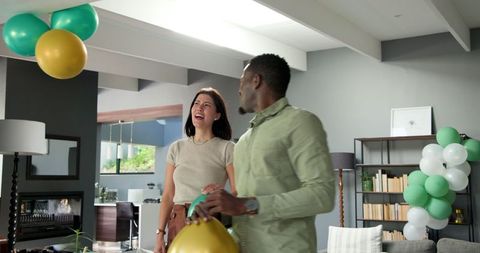 Couple Preparing for Birthday Celebration with Balloon Decorations