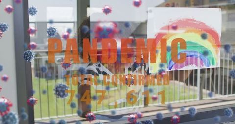 Pandemic text reflected in child's rainbow art at window