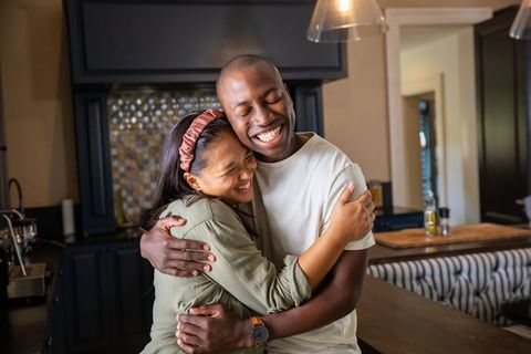 Diverse Couple Embracing Warmly at Home Kitchen