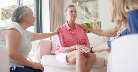 Senior friends providing compassionate support in comforting sitting