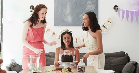 Woman celebrating birthday with friends in bright living room