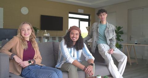 Diverse young professionals relaxing and collaborating in modern lounge with plants