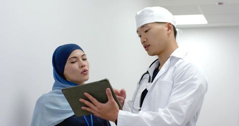 Physician and patient reviewing tablet during clinic consultation, collaborating on care plan