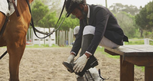 Male equestrian wearing riding boots near horse on rural farm - Download Free Stock Images Pikwizard.com