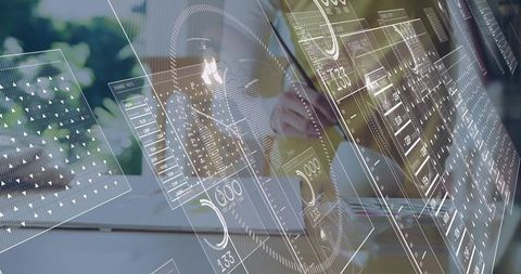 Woman tapping tablet and using laptop with augmented reality dashboard overlays at home office