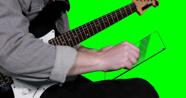 Musician using tablet while playing electric guitar - Download Free Stock Images Pikwizard.com