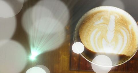 Latte art rosetta in ceramic cup on wooden coaster with bokeh light and warm cozy ambiance