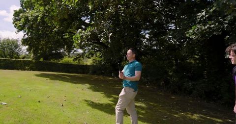 Male friends practicing golf swing outdoors