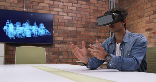 Caucasian professional businessman working in a modern office, wearing VR headset, moving his hands 3d model displayed on screen in the background. Business creativity technology.