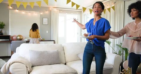 Joyful Women Cleaning Up at Birthday Celebration