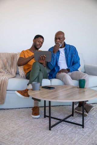 Father and Son Sharing Bonding Time at Home with Tablet