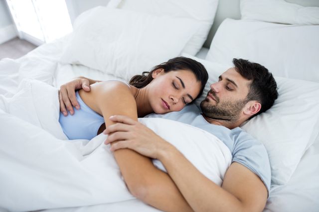 Young romantic couple sleeping on bed in bedroom