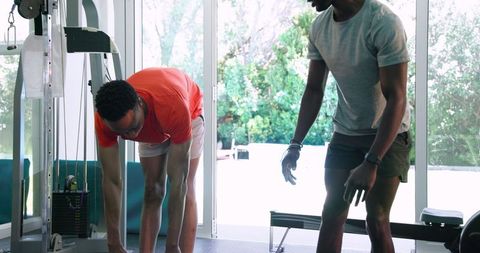 Young men stretching and exercising together in bright gym