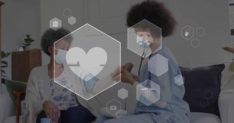 Homecare nurse checking blood pressure for senior woman on sofa with digital health icons