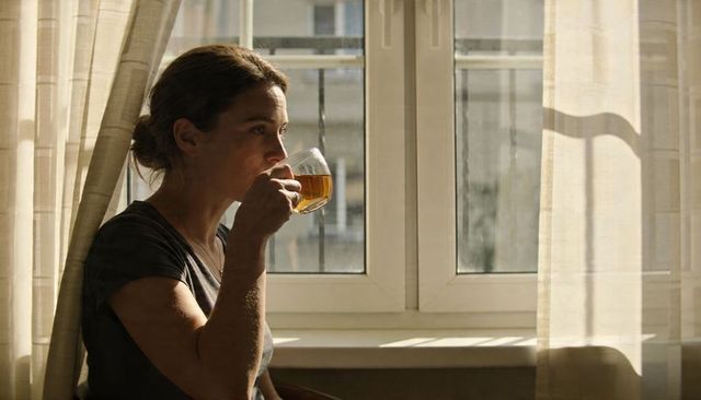 Sipping tea and gazing out window in morning sunlight serene minimalist moment