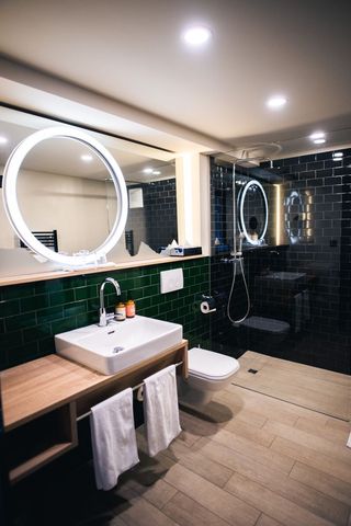Modern bathroom with circular mirror and rain shower