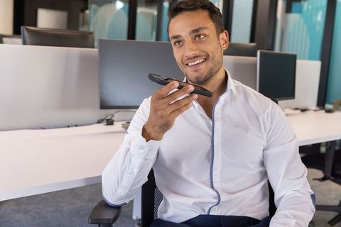 Confident professional communicating on smartphone in modern office