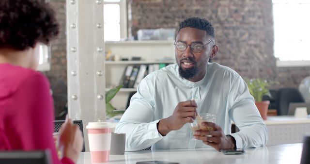 Young Man Eating Lunch While Engaging in Conversation at Modern Office - Download Free Stock Images Pikwizard.com