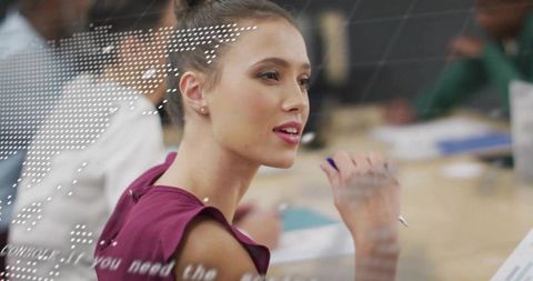 Young businesswoman leading strategic meeting in modern boardroom holding pen and documents