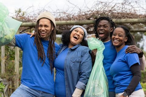 African american volunteers celebrating community cleanup and teamwork in garden