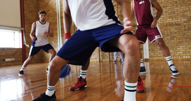 Basketball players in mid-game action indoors on wooden floor - Download Free Stock Images Pikwizard.com