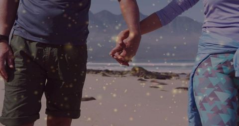 Couple Holding Hands Strolling on Refreshing Beach with Scenic Mountain View